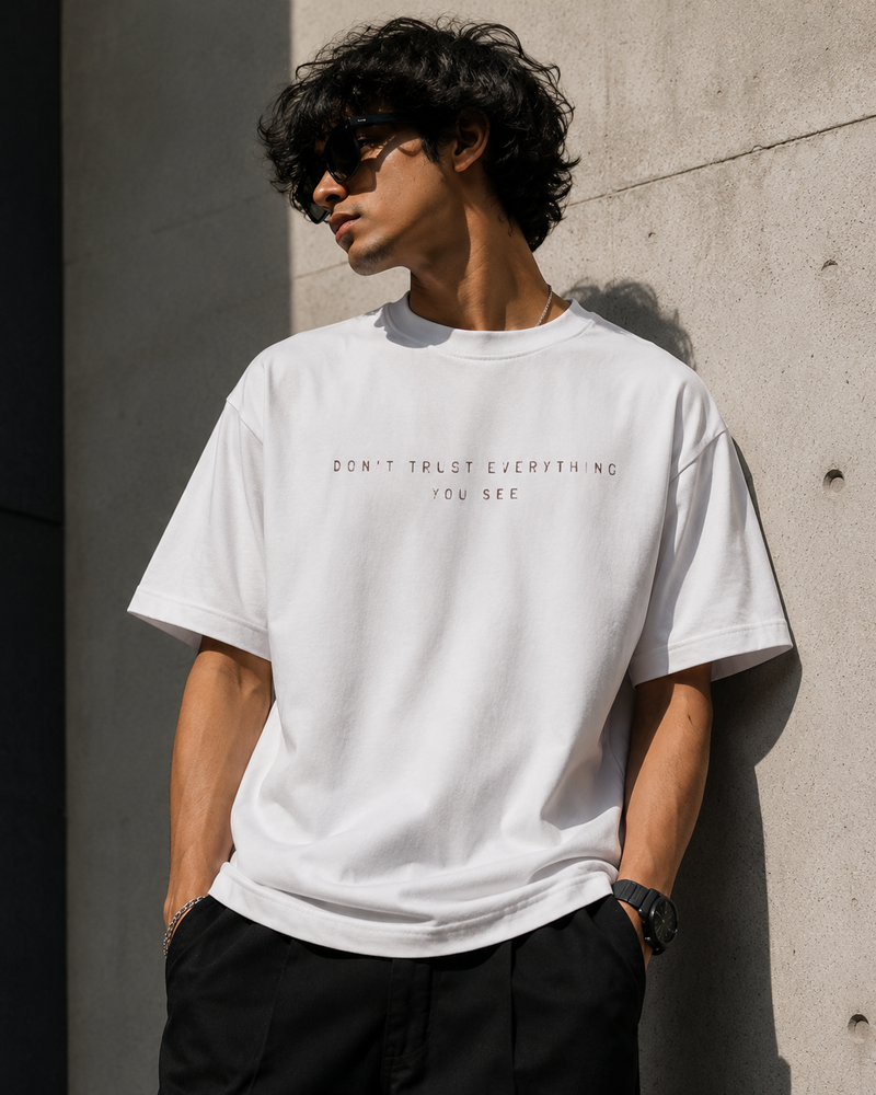 RAVYNN Oversized White T-Shirt – "Realistic / Don't Trust Everything You See" Sculpture Back Graphic